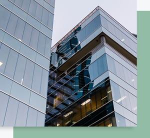 Immeuble tertiaire moderne avec façades vitrées reflétant des bâtiments voisins