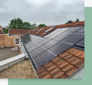 Panneaux solaires installés sur la toiture en tuiles d’un bâtiment avec environnement arboré