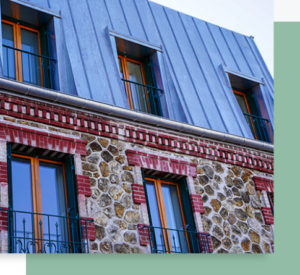 `Façade d’un bâtiment ancien en pierre et brique avec fenêtres en bois et toiture en métal**