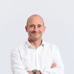 Personne portant une chemise blanche avec les bras croisés sur fond clair