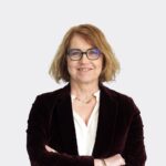 Personne portant une veste bordeaux et un haut blanc sur fond clair