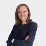 Personne en haut bleu foncé avec les bras croisés sur fond clair